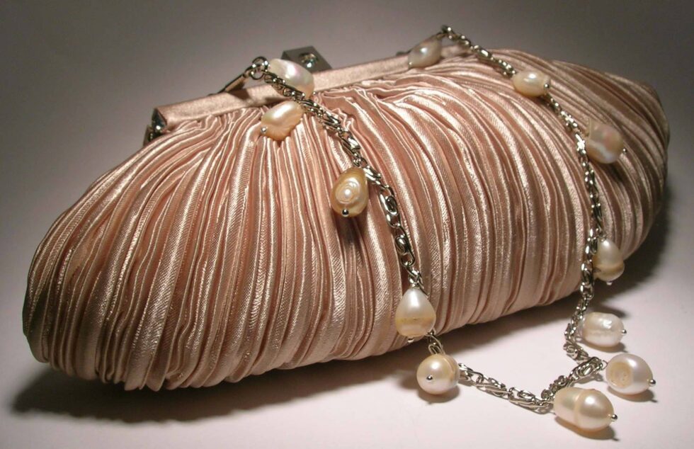 Ivory satin clutch with pleated pattern with chain and pearls