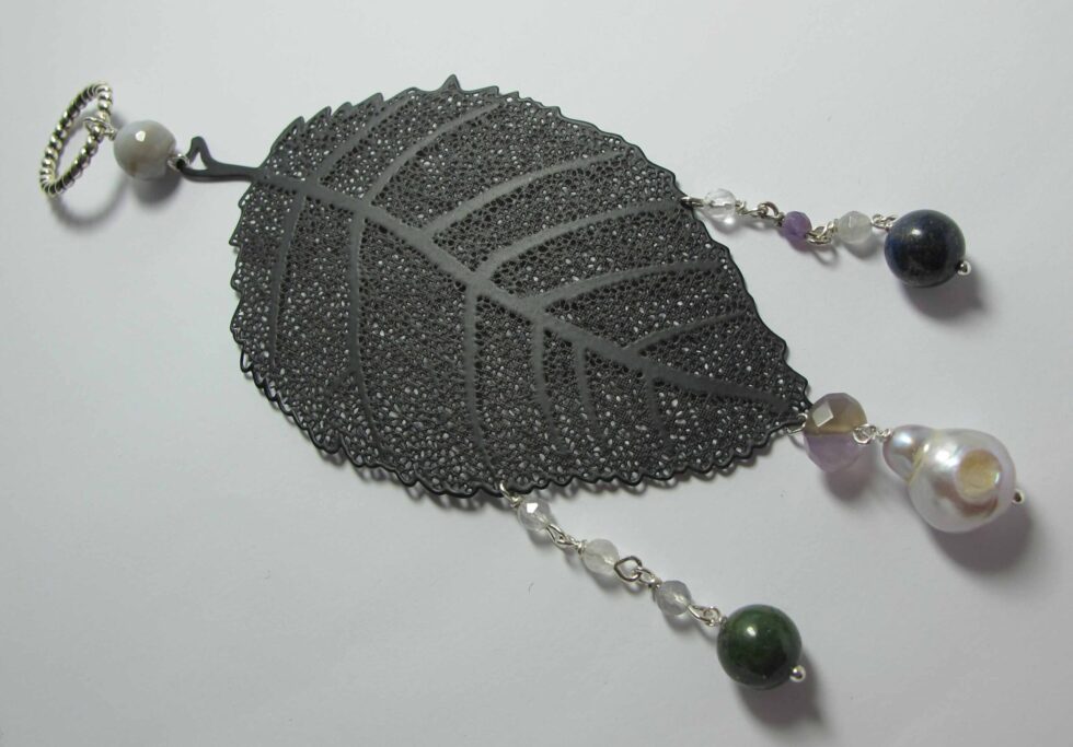 Pendant with pearl, lapis lazuli, jade African, agate, quartz and amethyst on a metal leaf