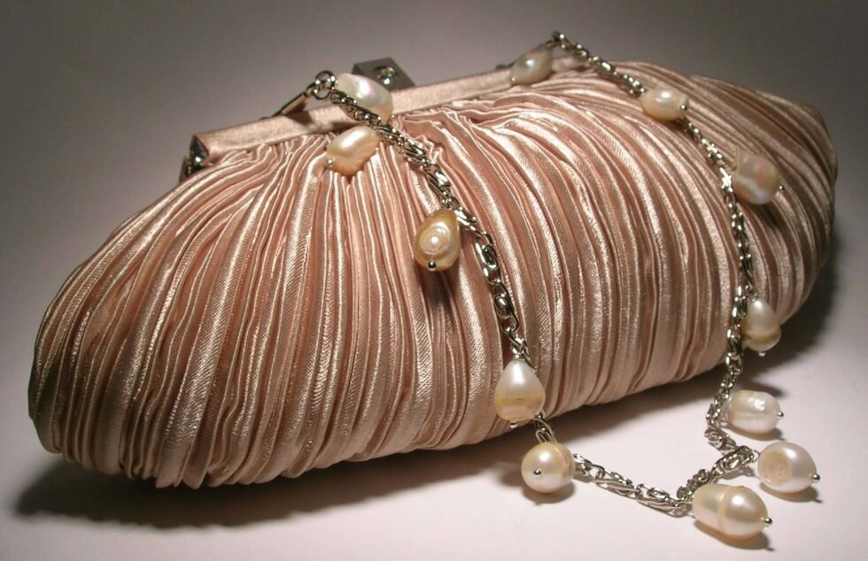 Ivory satin clutch with pleated pattern with chain and pearls